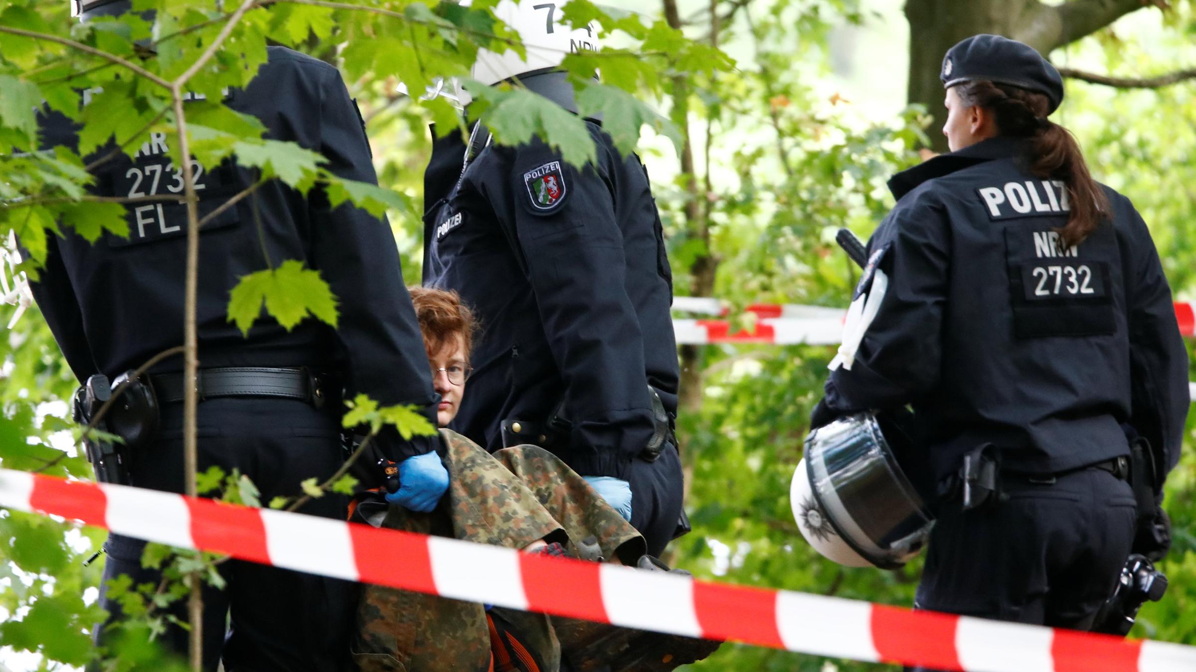 Einsatzkräfte der Polizei tragen Aktivisten aus dem Wald