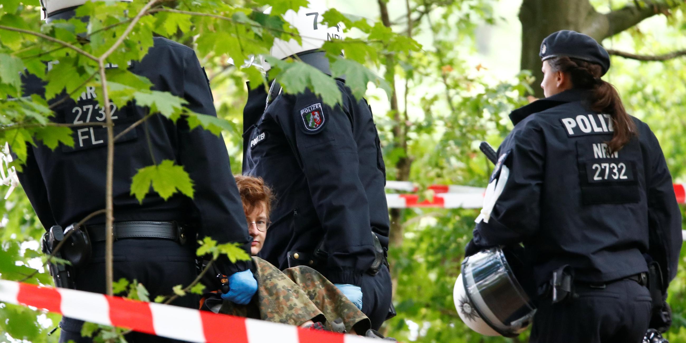 Einsatzkräfte der Polizei tragen Aktivisten aus dem Wald