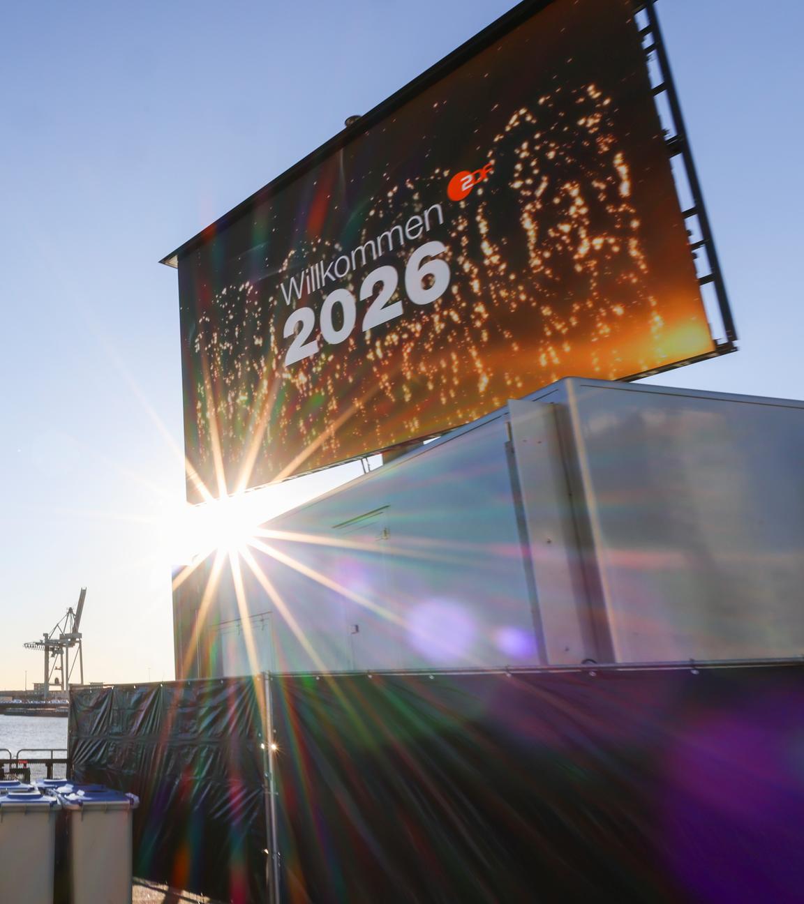 "Willkommen 2026" steht auf einem großen Monitor bei Aufbauarbeiten für die ZDF-Silvestershow am Chicagokai vor dem Westfield Hamburg-Überseequartier in der Hafencity. 