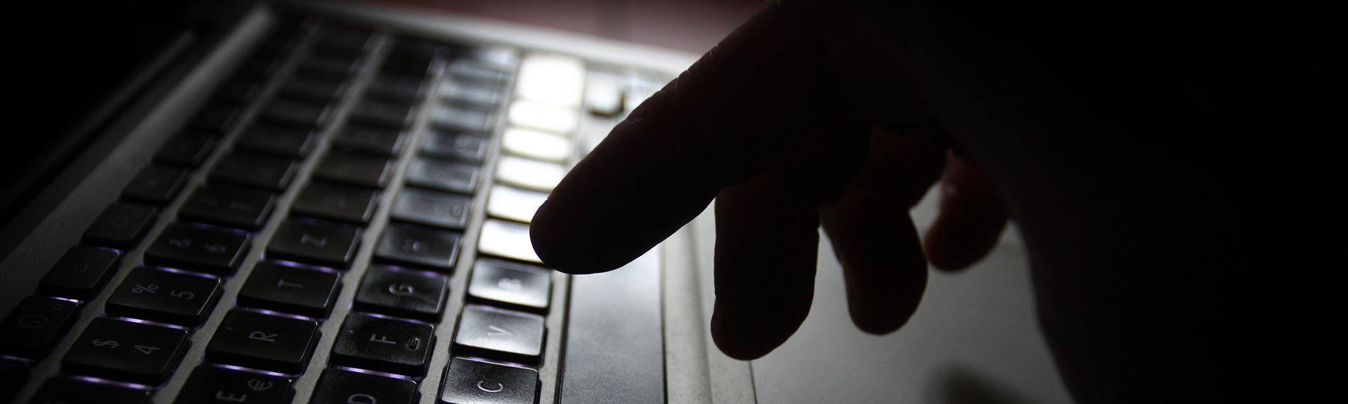 Hand an der Tastatur eines Laptops