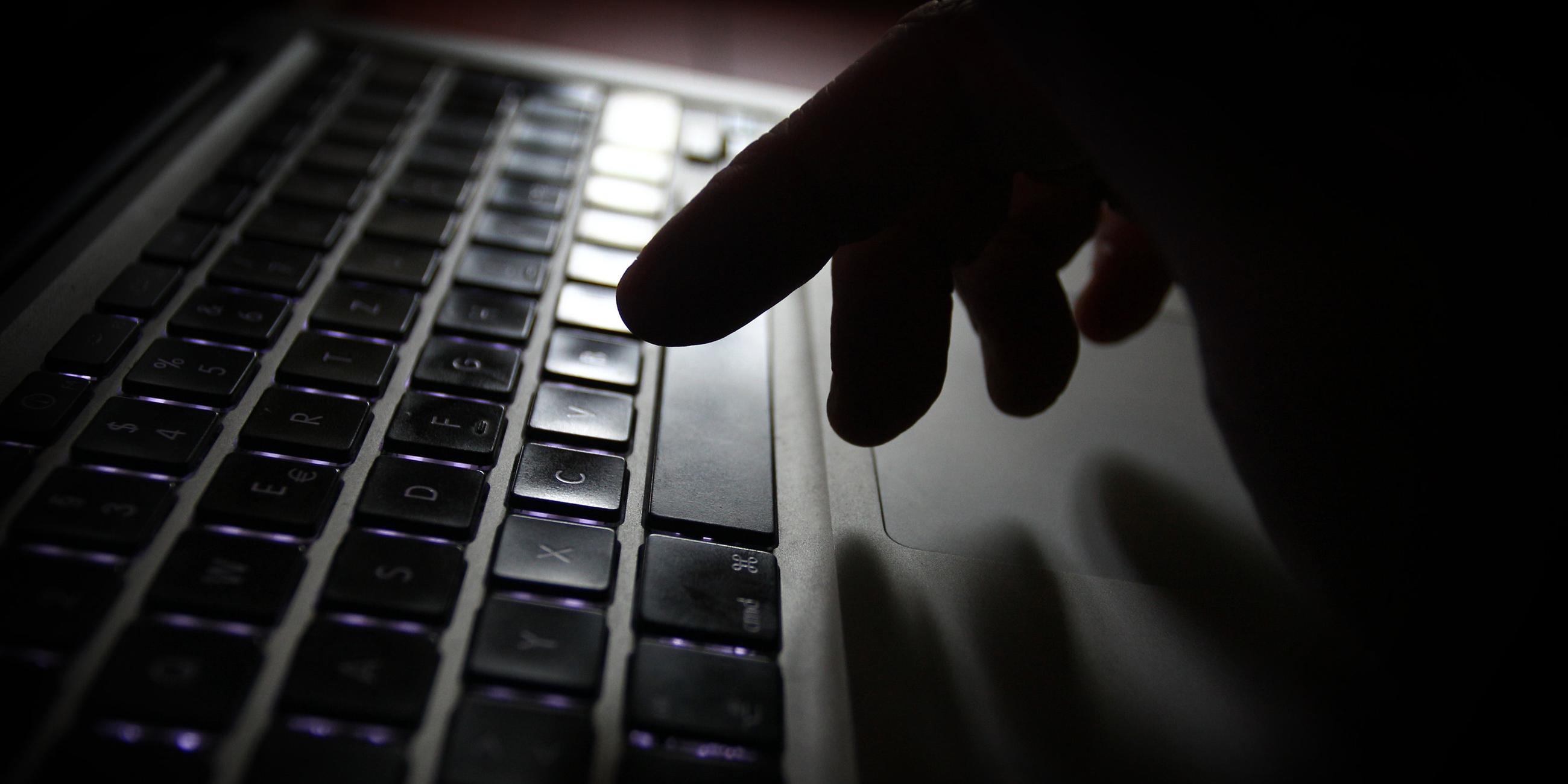 Hand an der Tastatur eines Laptops