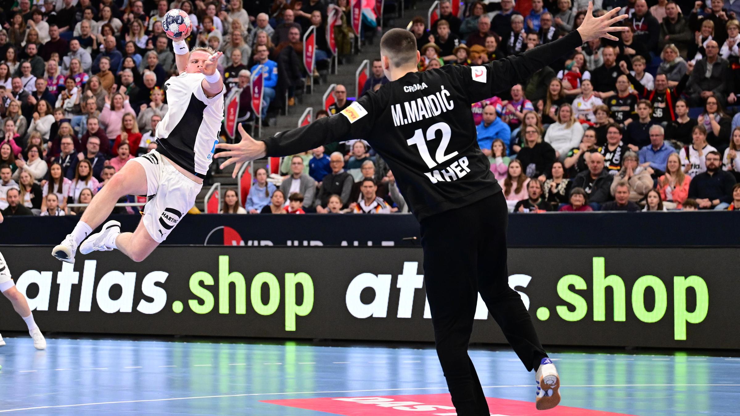 Justus Fischer vollendet einen Konter mit einem Sprungwurf. Kroatiens Torwart Matej Mandic breitet die Arme aus.