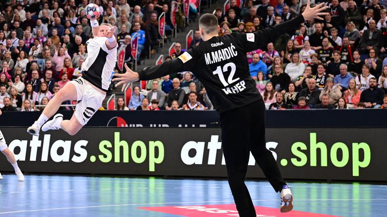 Justus Fischer vollendet einen Konter mit einem Sprungwurf. Kroatiens Torwart Matej Mandic breitet die Arme aus.