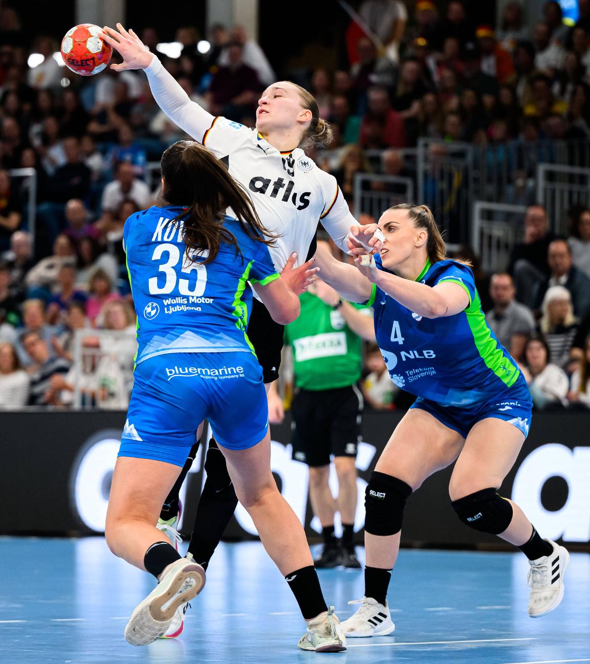 Die deutsche Handballnationalspielerin Nieke Kühne wird im Zweikampf von den slowenischen Handballnationalspielerinnen Nina Kovsca und Erin Novak bedrängt 