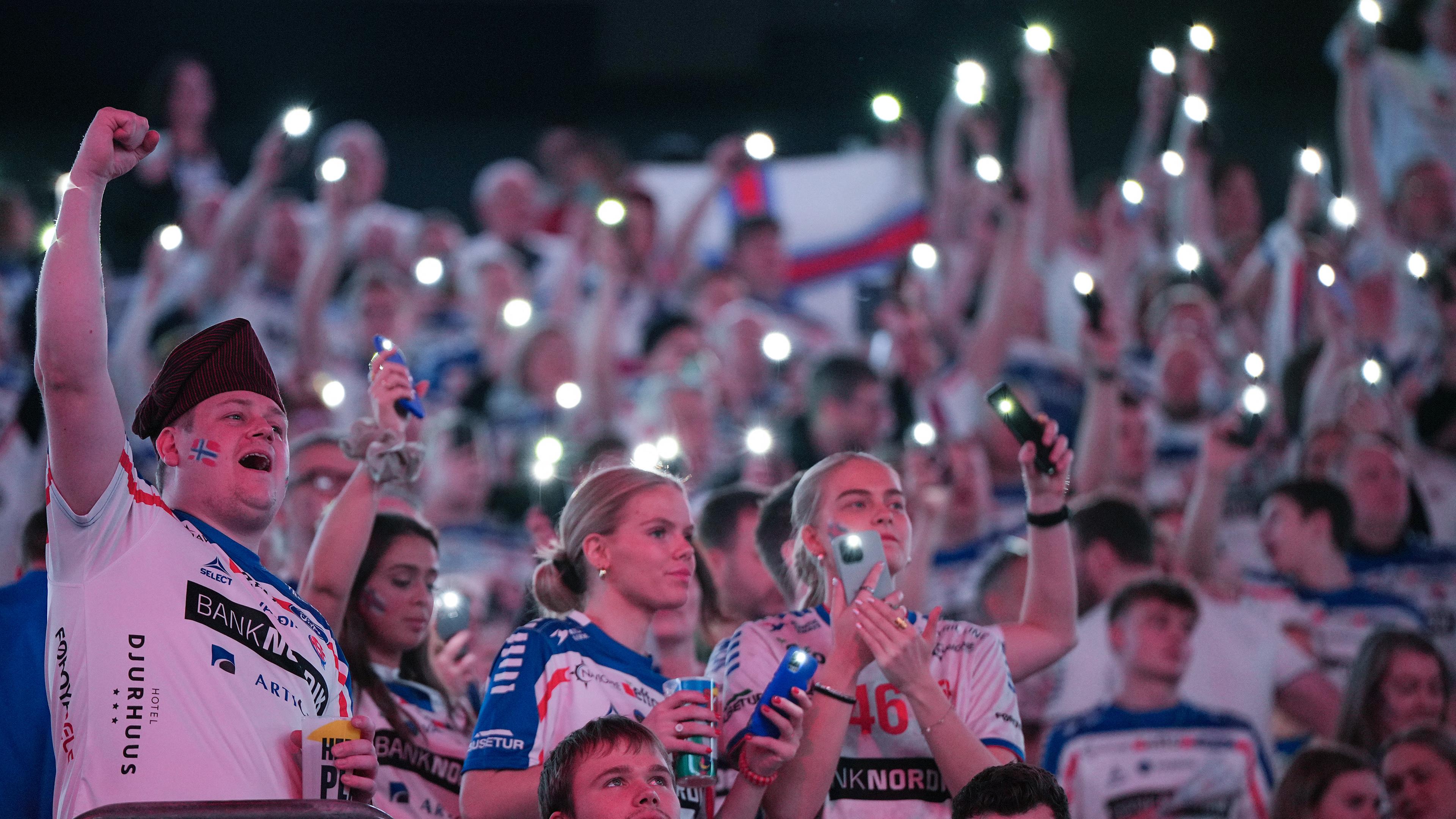 Berlin: Handball: EM, Färöer - Norwegen, Vorrunde, Gruppe D, 2. Spieltag, Fans der Mannschaft der Faröer Inseln begrüßen die Spieler mit leuchtenden Smartphones.