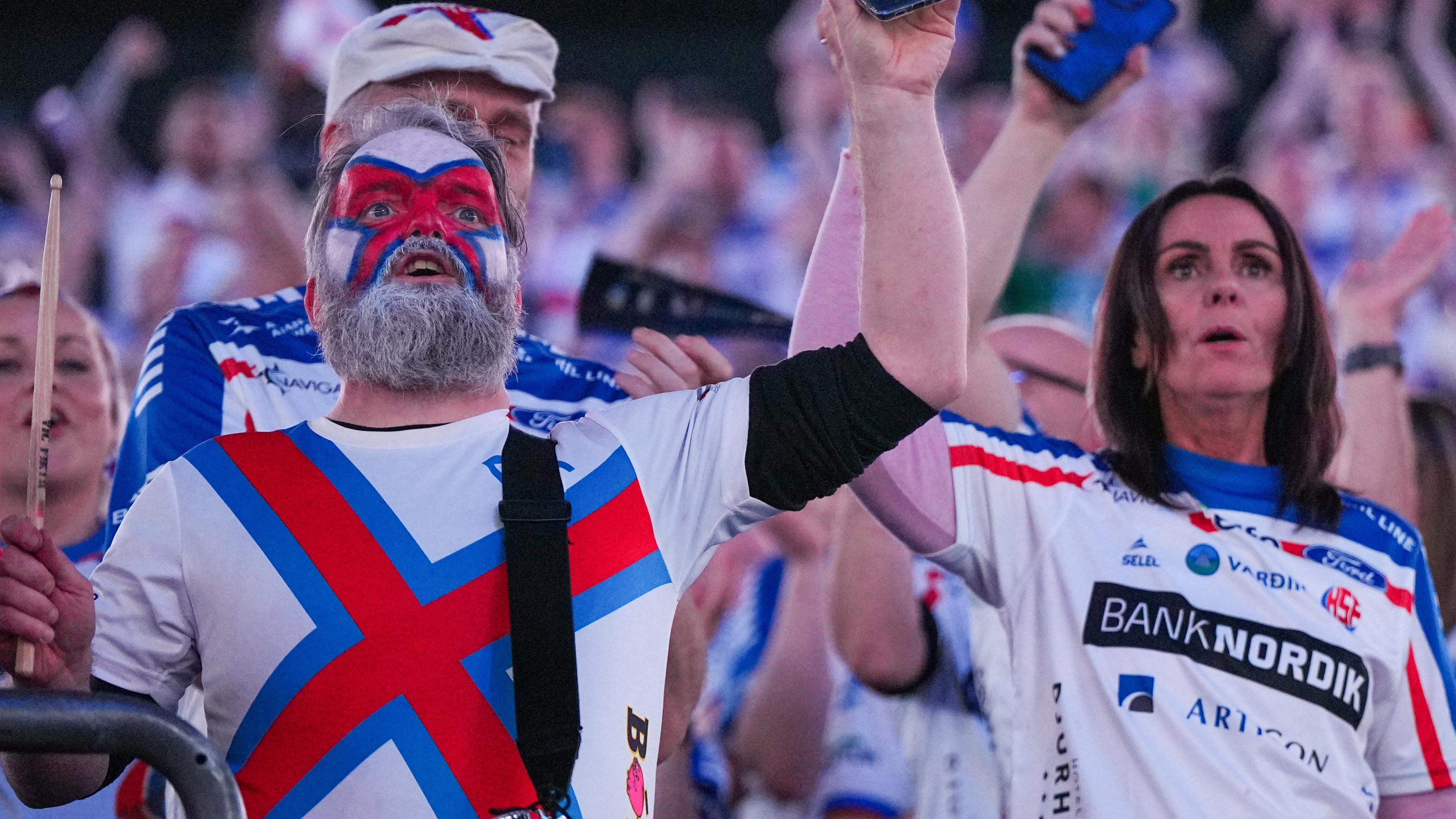 Berlin: Handball: EM, Färöer - Norwegen, Vorrunde, Gruppe D, 2. Spieltag, Fans der Mannschaft der Faröer Inseln begrüßen die Spieler mit leuchtenden Smartphones.