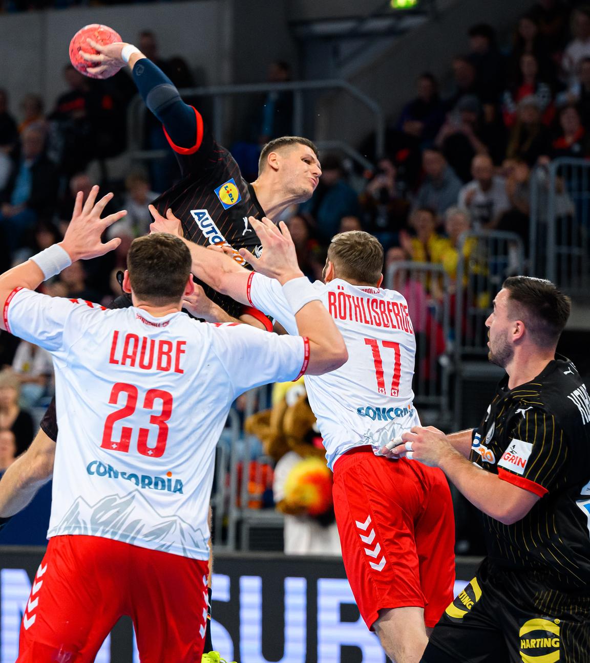 Baden-Württemberg, Mannheim: Handball: EM-Qualifikation, Deutschland - Schweiz, 2. Qualifikationsrunde, Gruppe 7, 1. Spieltag, Die Schweizer Spieler Lukas Laube (l) und Samuel Röthlisberger (M) in Aktion gegen Deutschlands Spieler Sebastian Heymann (2.v.l) und Jannik Kohlbacher (2.v.r).