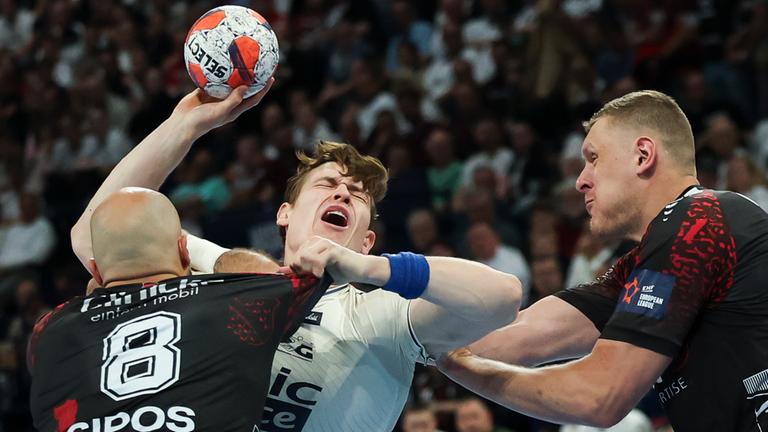 Flensburgs Lukas Lindhard Jörgensen wird von Melsungens Adrian Sipos und Dainis Kristopans am Wurf gehindert.