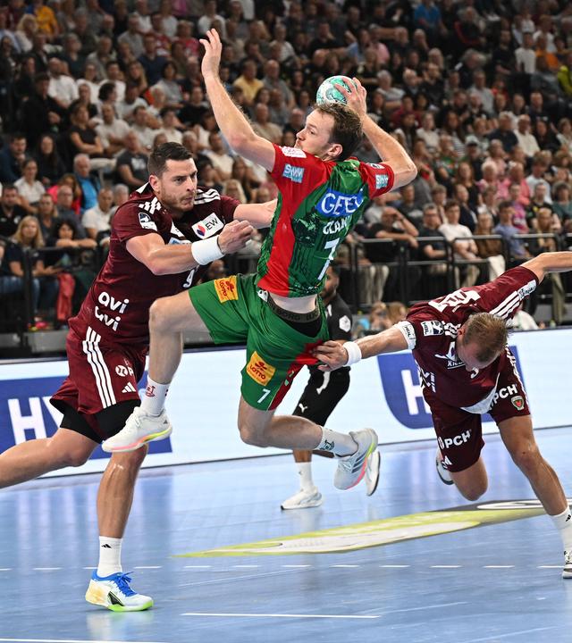 Handball, SC Magdeburg - Füchse Berlin: Mijajlo Marsenic (l) und Max Darj (2. v r) von Füchse Berlin blocken Felix Claar (2.v.l.) und Magnus Sugstrup (r) von SC Magdeburg.