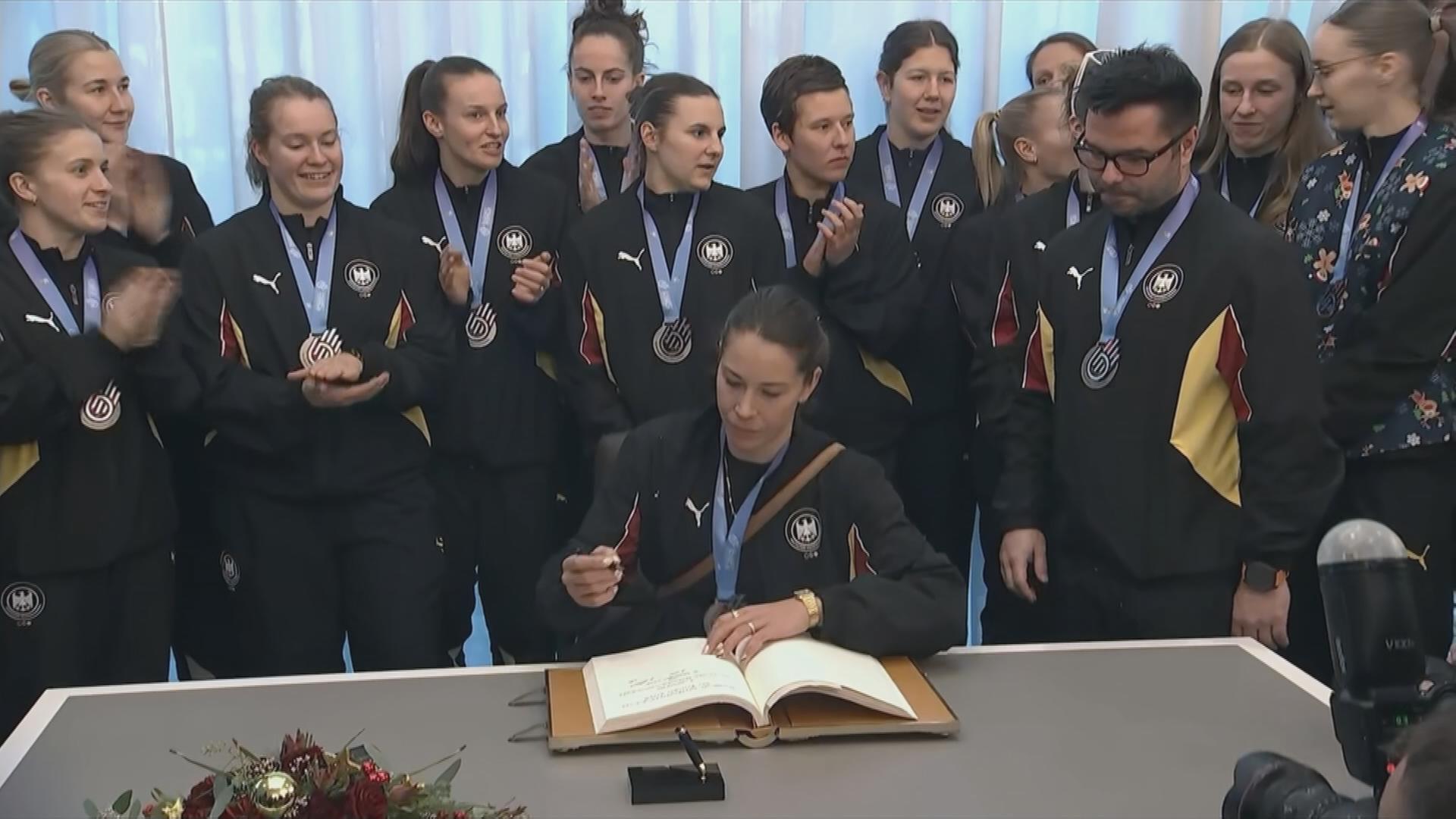 Die deutschen Handball-Frauen tragen sich ins Goldene Buch der Stadt Dortmund ein.