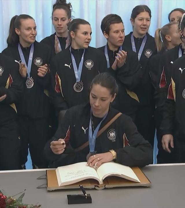 Die deutschen Handball-Frauen tragen sich ins Goldene Buch der Stadt Dortmund ein.