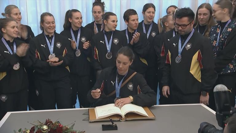 Die deutschen Handball-Frauen tragen sich ins Goldene Buch der Stadt Dortmund ein.