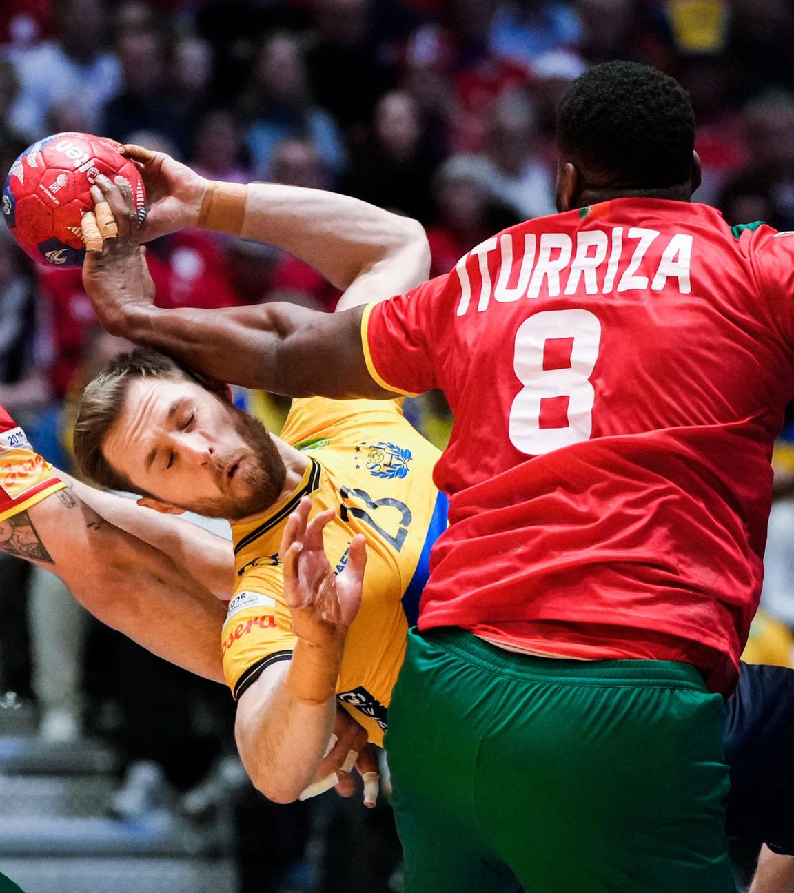 Zwei portugiesische Handballer versuchen einen schwedischen Handballer zu hindern, den Ball zu werfen. Dabei stoßen sie zusammen.