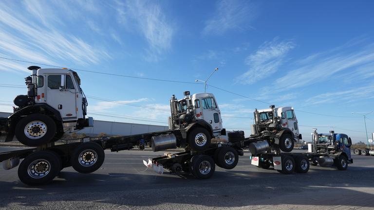 Mexiko, Mexicali: Ein Lastwagen zieht in Mexicali, Mexiko, frisch montierte Lkw-Fahrerhäuser über die Grenzbrücke von Mexiko in die Vereinigten Staaten.