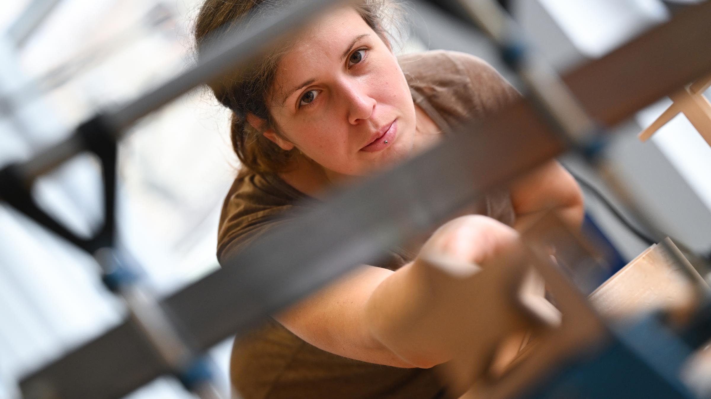Eine Frau arbeitet an einer Werkbank.