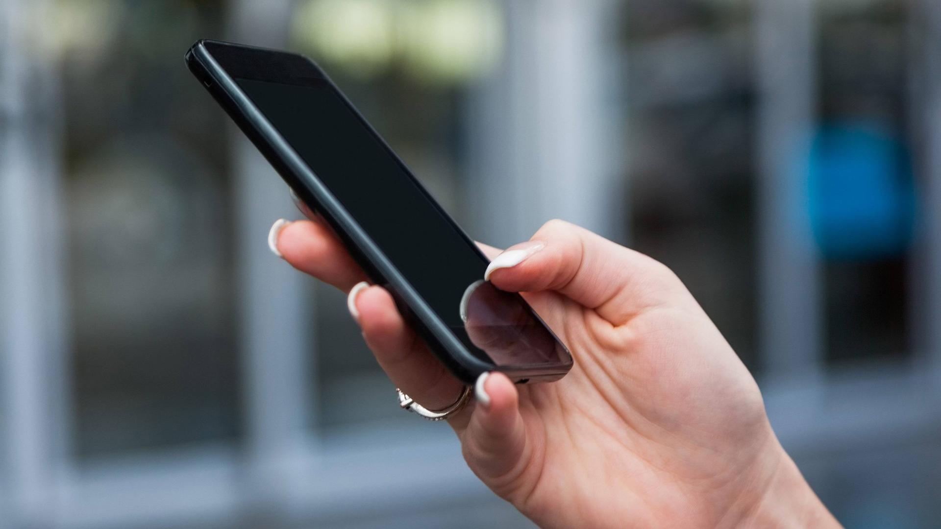 Frau hält ein Handy