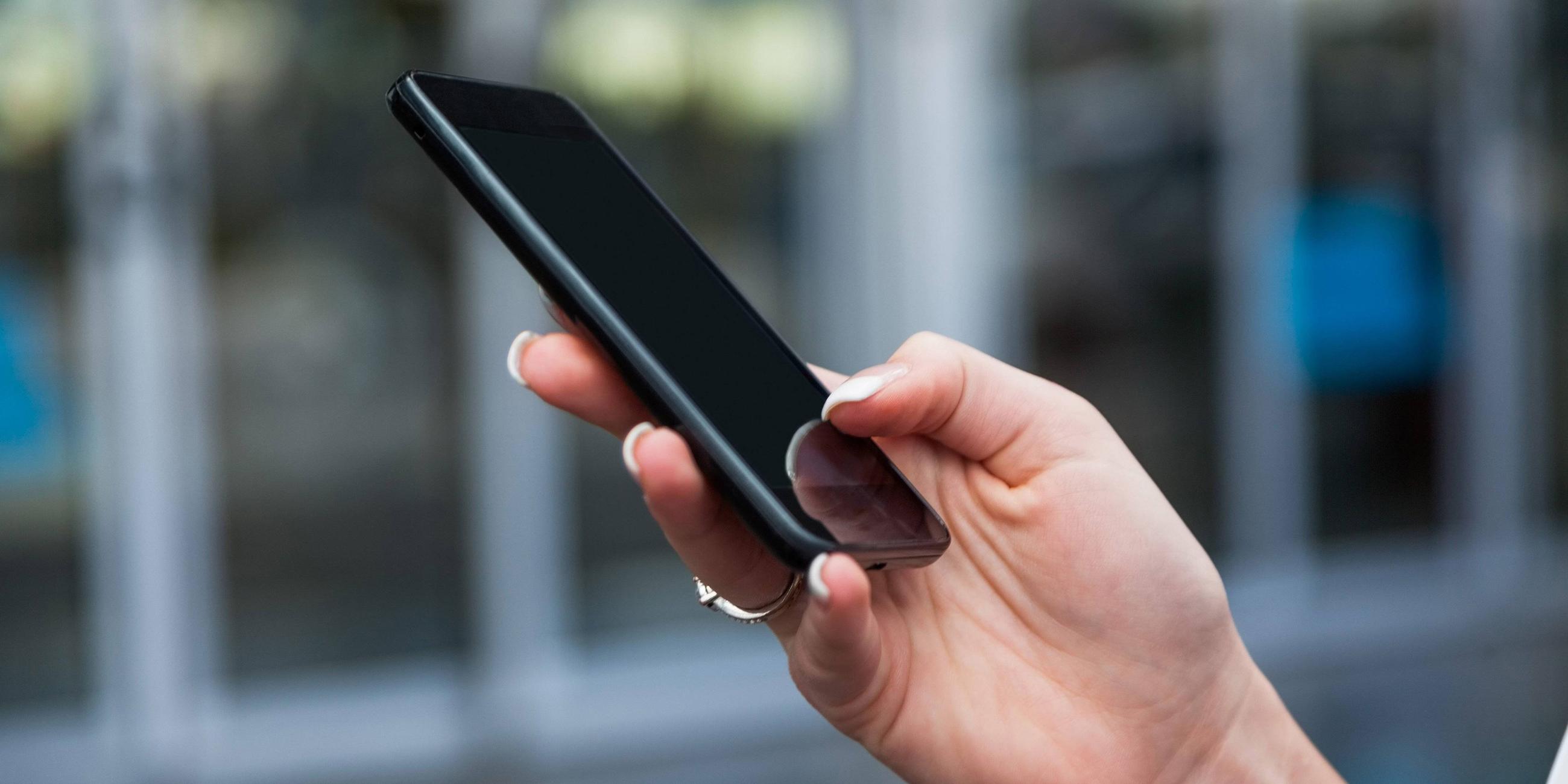 Frau hält ein Handy