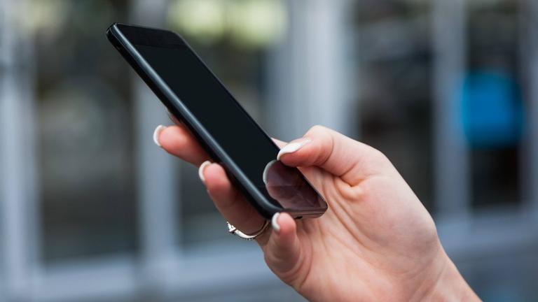 Frau hält ein Handy