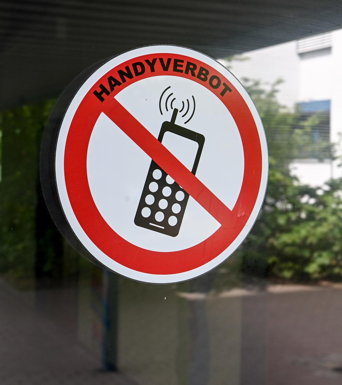 An einer Glastür klebt ein Verbotsschild mit der Aufschrift: "Handyverbot".