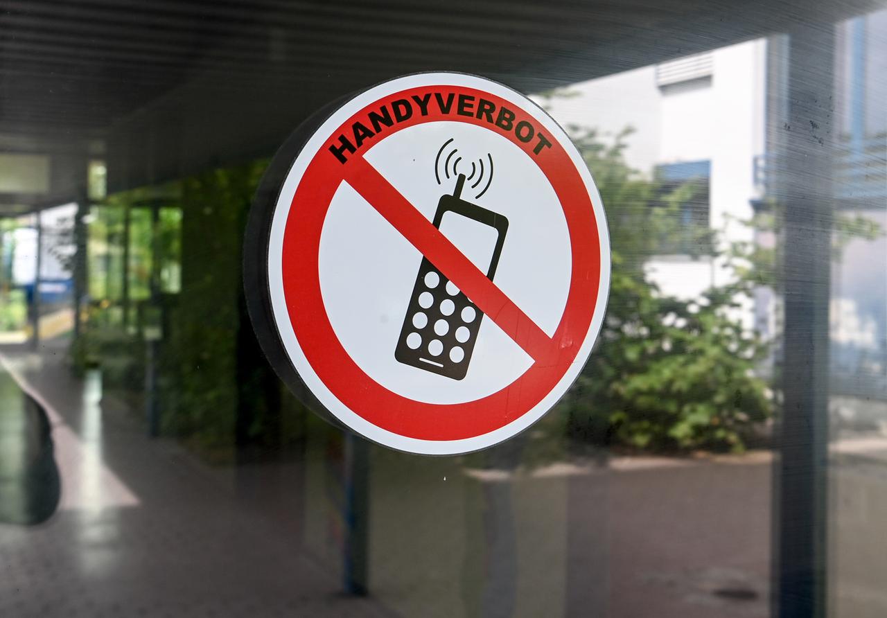 An einer Glastür klebt ein Verbotsschild mit der Aufschrift: "Handyverbot".