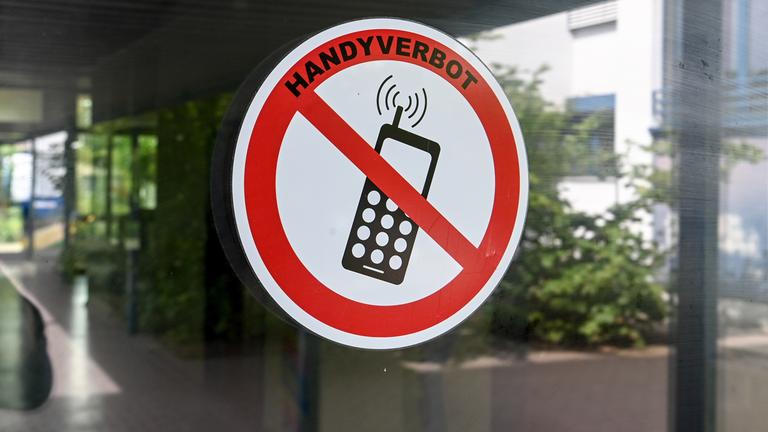 An einer Glastür klebt ein Verbotsschild mit der Aufschrift: "Handyverbot".