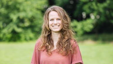 Hanna Kuhfuss steht auf einer Wiese und lächelt in die Kamera