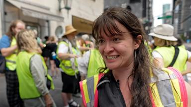 Hannah Stauss trägt eine Warnweste, im Hintergrund sieht man weitere Menschen mit Warnwesten