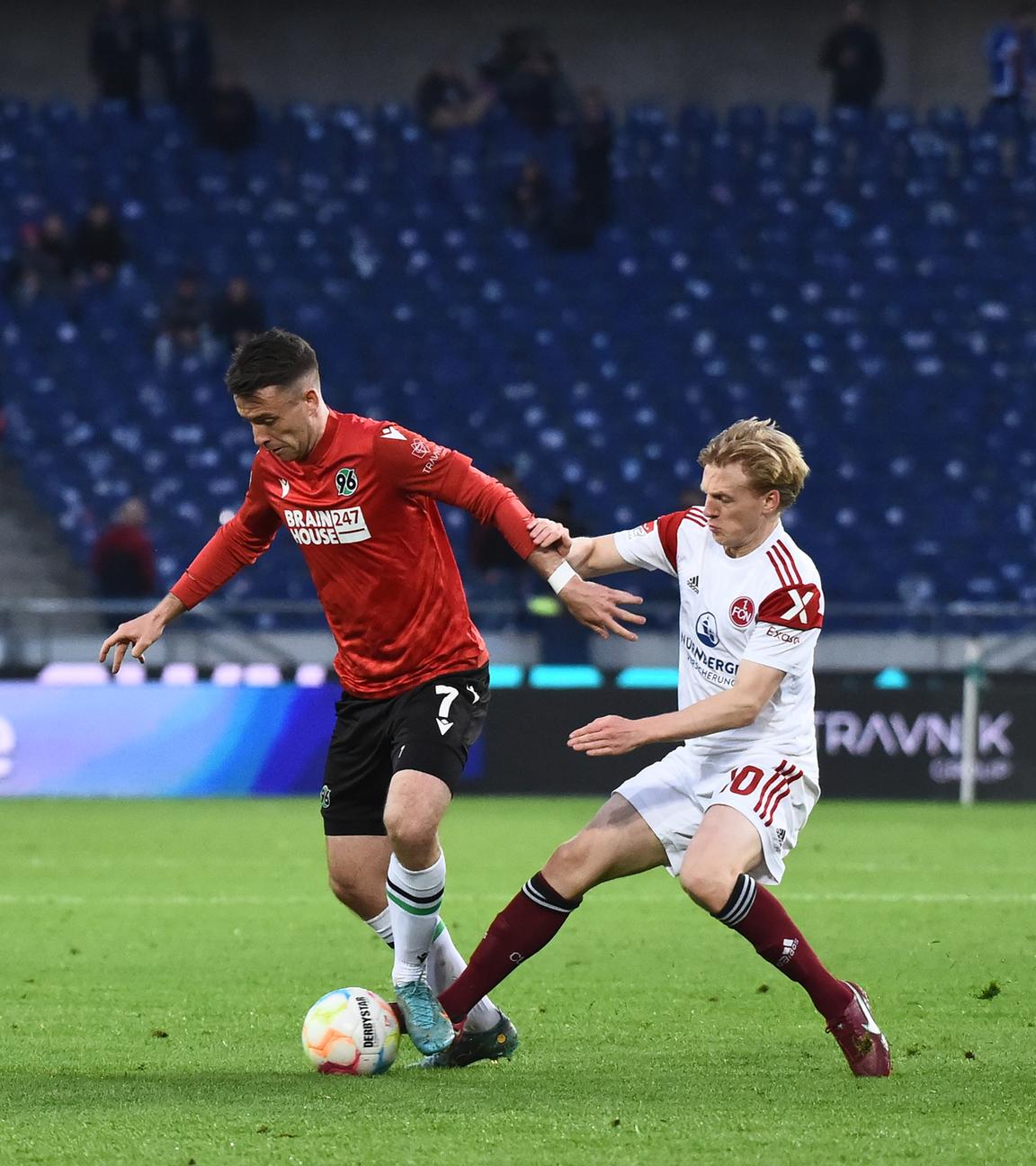 29.04.2023, Niedersachsen, Hannover: Fußball: 2. Bundesliga, Hannover 96 - 1. FC Nürnberg, 30. Spieltag, Heinz von Heiden-Arena. Nürnbergs Mats Möller Daehli (r) versucht Hannovers Max Besuschkow (M) den Ball wegzunehmen während Schiedsrichter Felix Zwayer zuschaut.