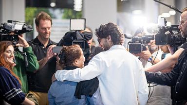 Menschen aus Afghanistan, die zuvor mit einem Flugzeug auf dem Flughafen Hannover-Langenhagen gelandet sind, spechen zu Pressevertretern.