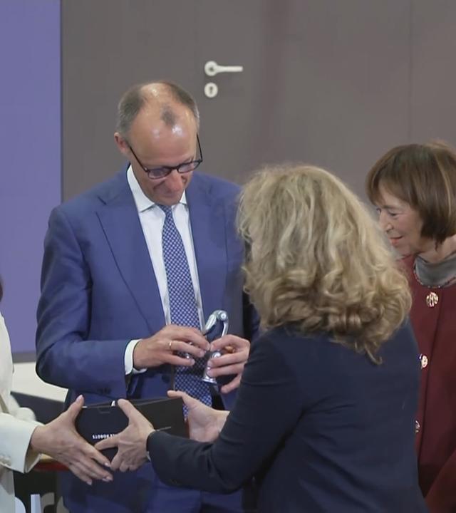Kanzler Merz in Begleitung auf der Messe Hannover