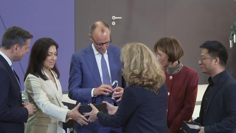 Kanzler Merz in Begleitung auf der Messe Hannover