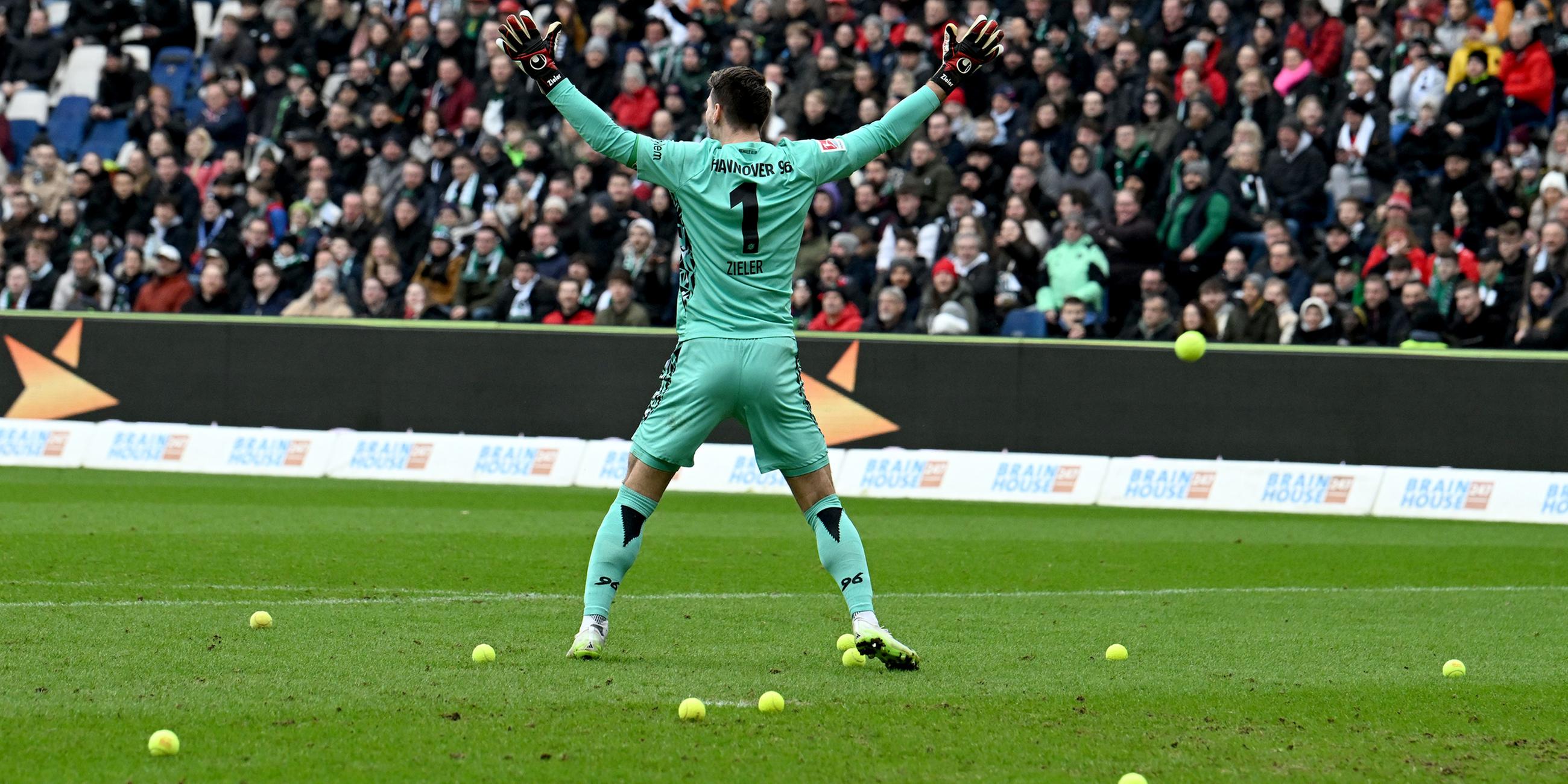 Hannovers Torwart Ron-Robert Zieler gestikuliert während des Spiels weil Tennisbälle geworfen werden.