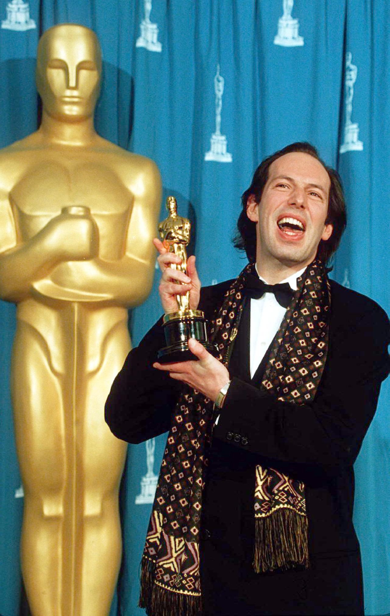 Hans Zimmer hält einen Oscar in den Händen.