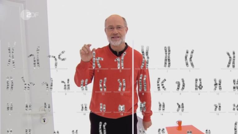 Harald Lesch hinter einer Tafel mit Abbildung von Genen