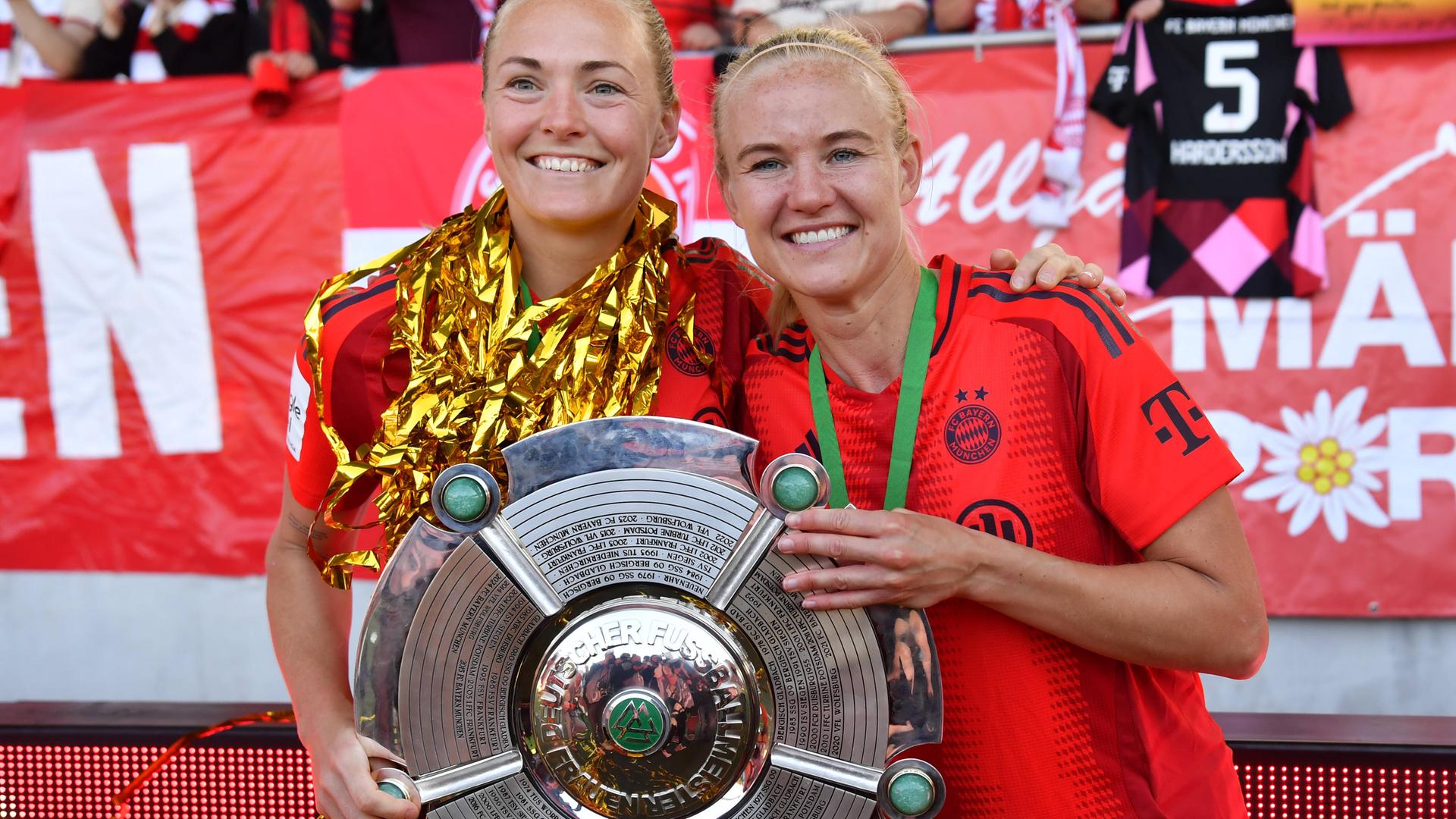 Magdalena Eriksson (links) und Pernille Harder (beide FC Bayern) halten Meisterschale in der Hand.