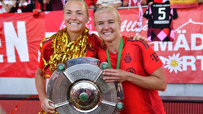 Magdalena Eriksson (links) und Pernille Harder (beide FC Bayern) halten Meisterschale in der Hand.