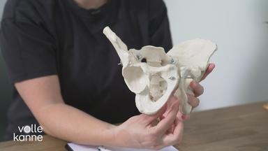 Ärztin zeigt auf Beckenskelett