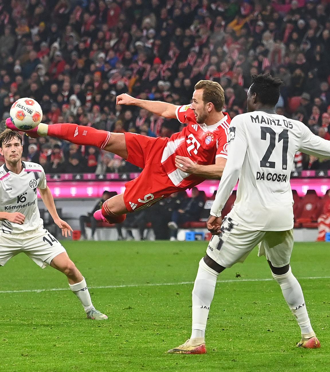 Bayerns Stürmer Harry Kane versucht mit einem Seitfallzieher im Mainzer 16er das Tor zu erzielen.