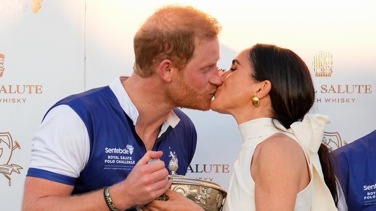 12.04.2024, USA, Wellington: Der britische Prinz Harry (l), und seine Frau Meghan, Herzogin von Sussex, küssen sich, während sie seinem Polo-Team die Trophäe für den Sieg bei der Royal Salute Polo Challenge to Benefit Sentebale überreicht.