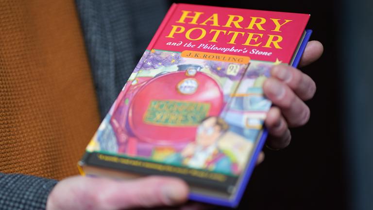 Großbritannien, Stafford: Auktionator Jim Spencer hält eine makellose Erstausgabe von J.K. Rowlings des Harry-Potter-Bands «Der Stein der Weisen» («The Philosopher's Stone») in der Hand.