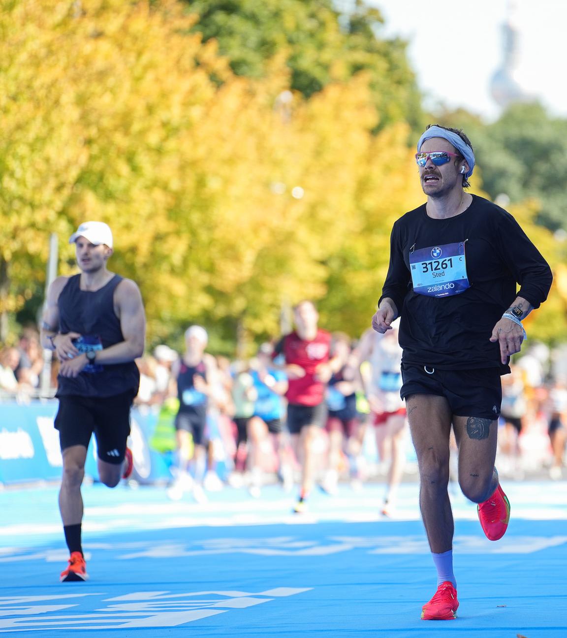 Der britische Sänger und Schauspieler Harry Styles mit Sonnenbrille und Stirnband beim BMW Berlin Marathon