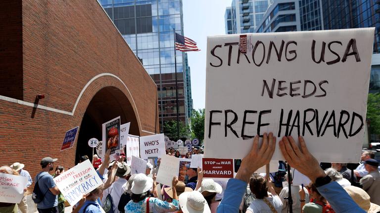 Menschen halten Plakate vor dem Gerichtsgebäude in Boston in die Höhe.