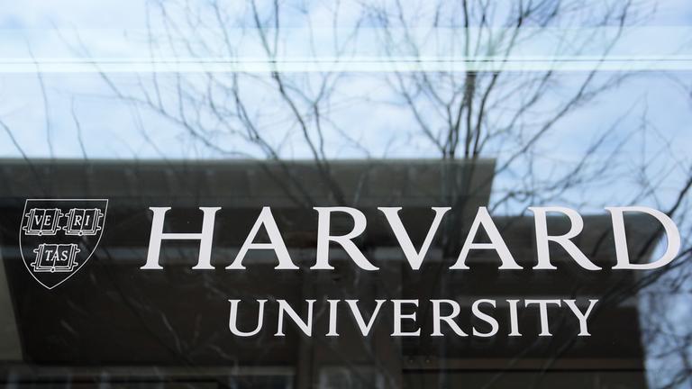 15.04.2025, USA, Cambridge: Das Logo der Harvard University prangt an einem Gebäude der Hochschule.