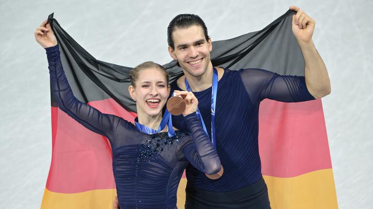 Minerva Hase und Nikita Volodin aus Deutschland freuen sich mit der Landesfahne über die Bronzemedaille.