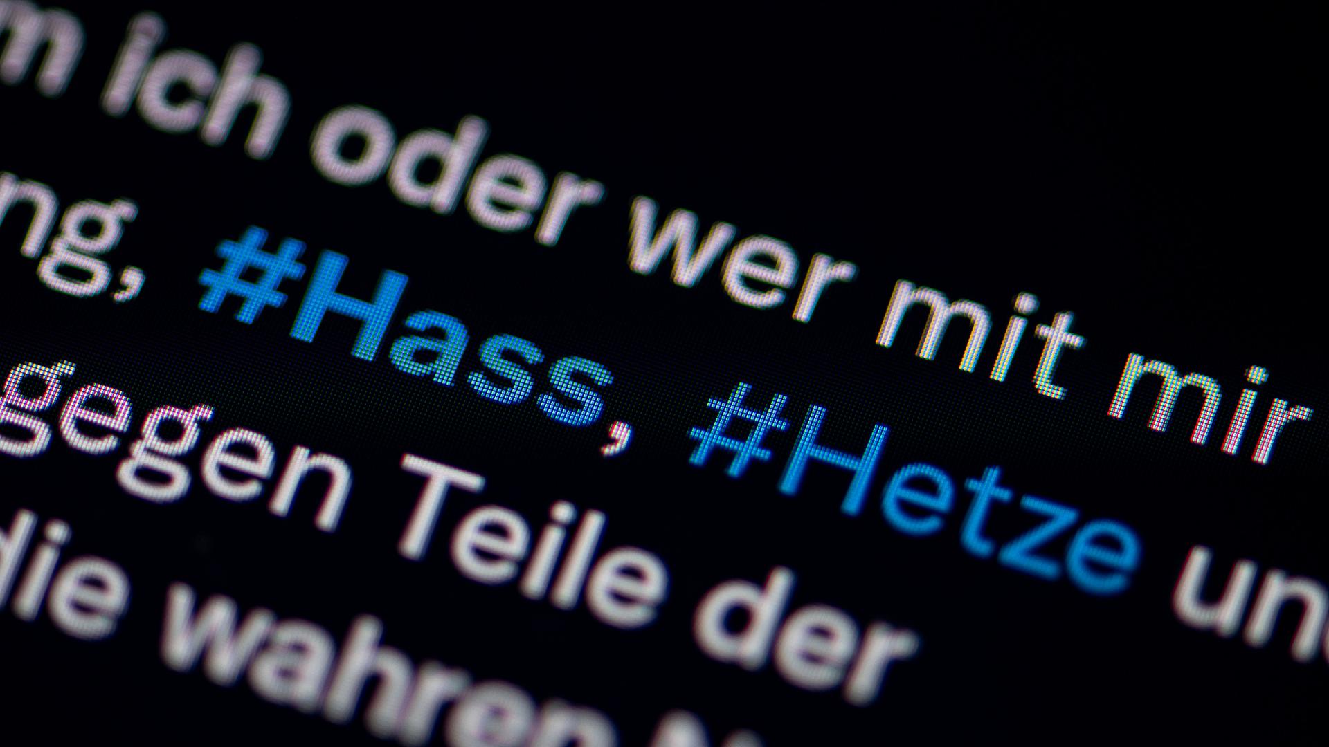 Auf dem Bildschirm eines Smartphones sieht man die Hashtags (#) Hass und Hetze in einem Post auf Twitter 