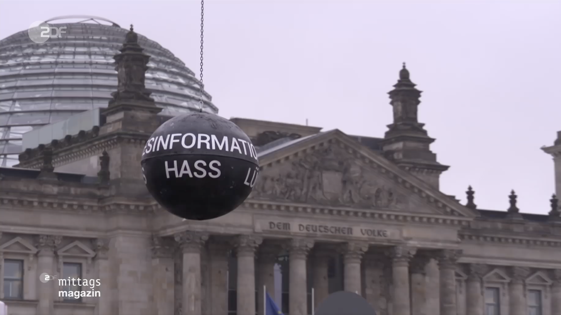 Eine Abrissbirne mit Aufschriften wie "Desinformation", "Lüge" und "Hass" steht vor dem Reichstagsgebäude in Berlin.