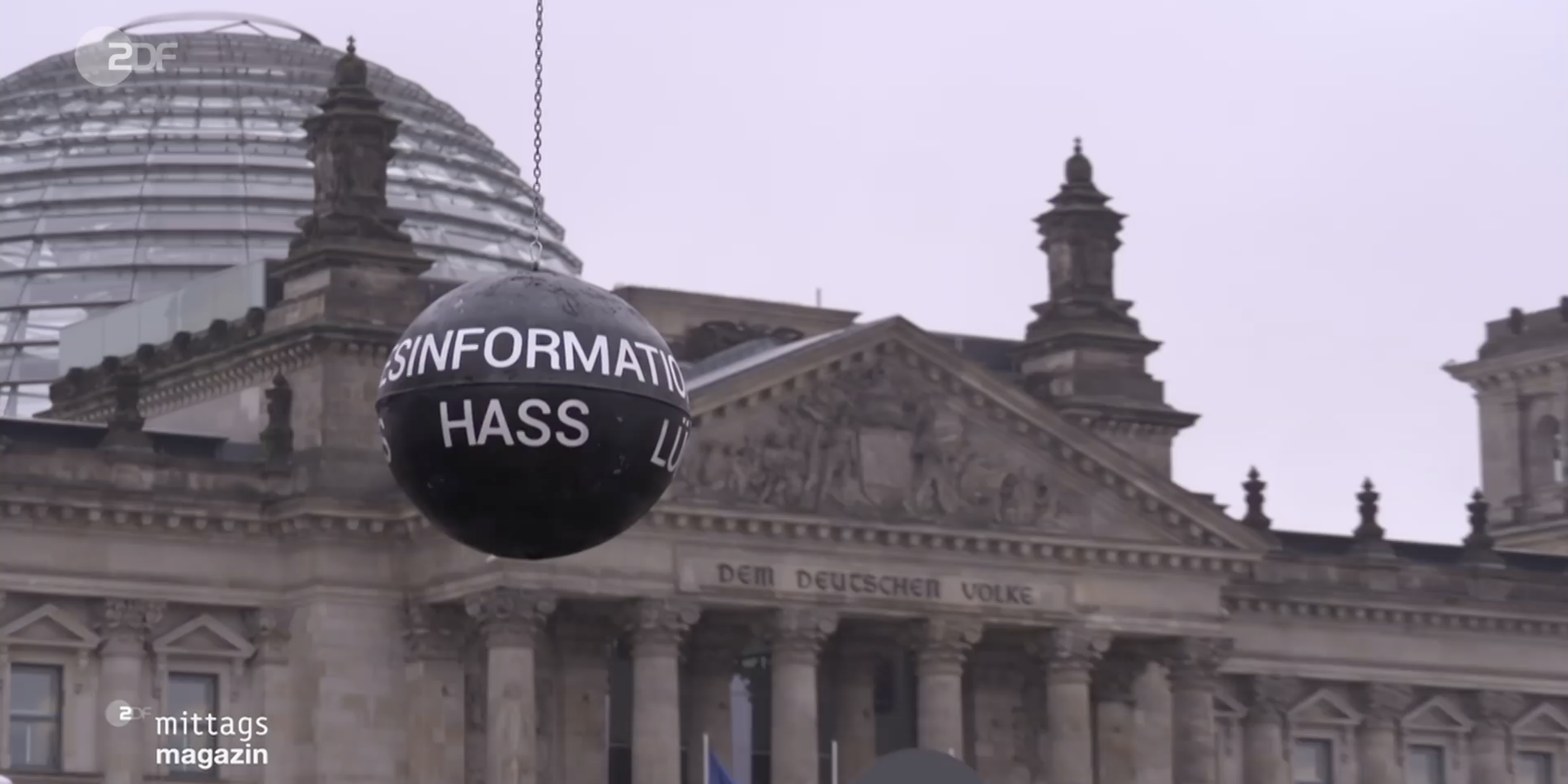 Eine Abrissbirne mit Aufschriften wie "Desinformation", "Lüge" und "Hass" steht vor dem Reichstagsgebäude in Berlin.
