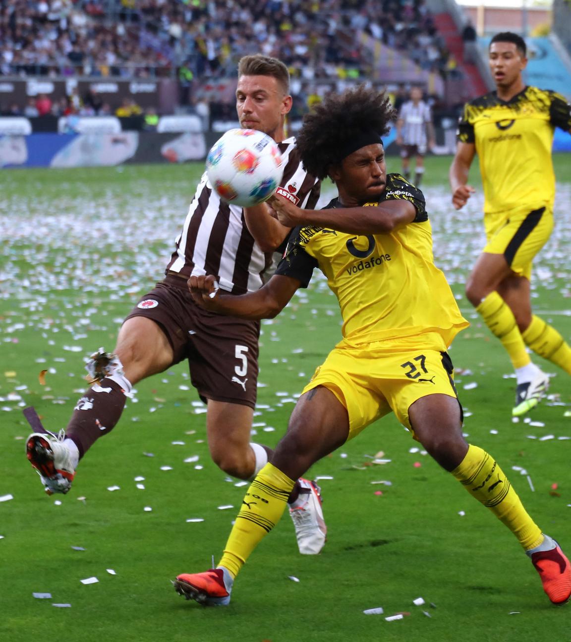 St. Paulis Verteidiger Hauke Wahl (#5,) und Dortmunds Stürmer Karim Adeyemi (#27) kämpfen im Bundesliga-Spiel um den Ball.