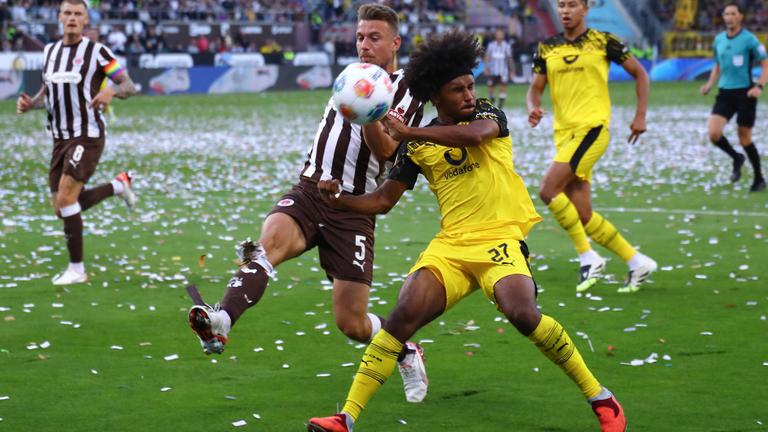 St. Paulis Verteidiger Hauke Wahl (#5,) und Dortmunds Stürmer Karim Adeyemi (#27) kämpfen im Bundesliga-Spiel um den Ball.