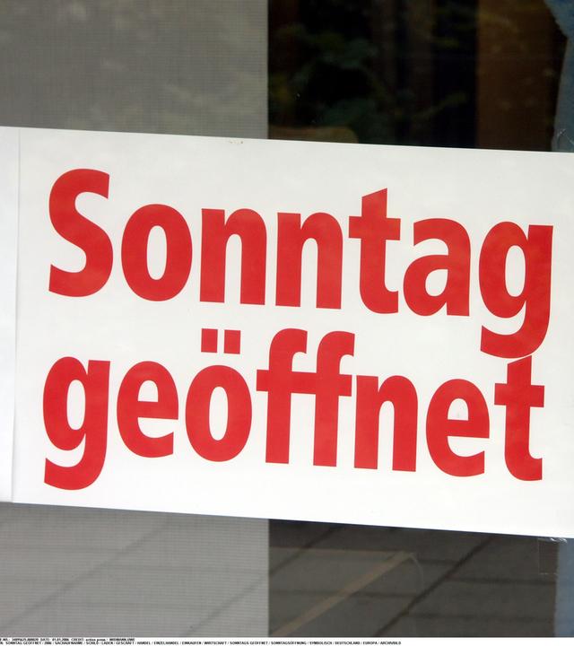 Auf einem Schild steht in roter Schrift "Sonntag geöffnet".